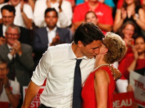 Federal Liberal leader Justin Trudeau and Ontario Premier Kathleen Wynne hug and kiss at a Liberal rally held at the Daniels Spectrum in Toronto's Regent Park on Monday August 17, 2015. (Jack Boland/Toronto Sun)