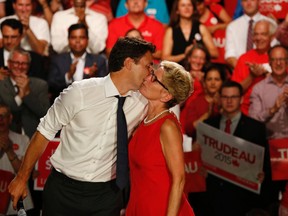 Federal Liberal leader Justin Trudeau (L) shows his gratitude to  Ontario Premier Kathleen Wynne (R) with a friendly hug and kiss at a Liberal rally held at the Daniels Spectrum in Regent Park on Monday August 17, 2015. Jack Boland/Toronto Sun/Postmedia Network