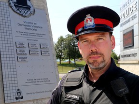 Kingston Police Const. Steve Koopman in front of the Victims of Domestic Violence Memorial at Kingston Police Headquarters on Monday. (Ian MacAlpine/The Whig-Standard)