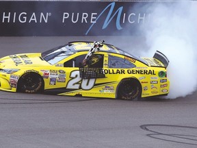Matt Kenseth, driver of the No. 20 Dollar General Toyota, celebrates with a burnout after winning the Pure Michigan 400 on Sunday. (AFP)
