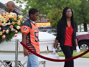 A former teammate and an unidentified fellow student help escort the casket of one of the children killed last week when eight family members were fatally shot last week, during funeral services in Houston, Texas, Aug. 17, 2015.  REUTERS/Dennis Spellman