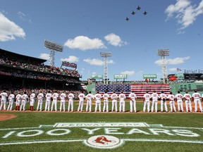 The Boston Red Sox and the Tampa Bay Rays line up for the national anthem during the home opener on April 13, 2012 at Fenway Park. (Elsa/Getty Images/AFP)