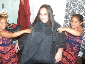 Wallaceburg's Tricia Nottley has her hair cut that she is donating to make wigs for kids with cancer. The hair is being cut by seven-year-old twins Alasia Travis and Kianna Travis. The twins, who are from Chatham, were diagnosed with cancer when they were 3 years-old and have undergone treatment and have been cancer-free since the spring of 2013. Nottley is a co-worker with the twins' mom Michelle Curran at Copper Terrace. This is Nottley's fifth time donating her hair, as she wanted to grow it and donate it in support of the twins.