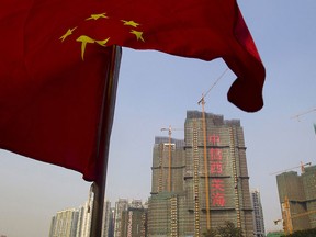 A Chinese national flag flutters on the Pearl River near a construction site in Guangzhou, Guangdong province, in this March 27, 2014 file photo. REUTERS/Alex Lee/Files