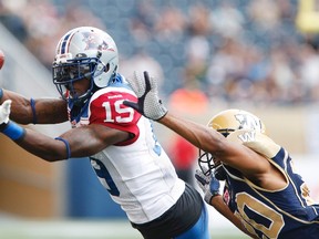 Montreal Alouettes’ S.J. Green (19) can’t hang onto a pass from quarterback Rakeem Cato during CFL action as Winnipeg Blue Bombers’ Johnny Adams defends in Winnipeg Friday, July 10, 2015. (THE CANADIAN PRESS/John Woods)