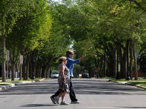 Two pedestrians walk through the a tree-lined 138 Street near 104 Avenue, in Edmonton Alta. on Tuesday Aug. 18, 2015. David Bloom/Edmonton Sun