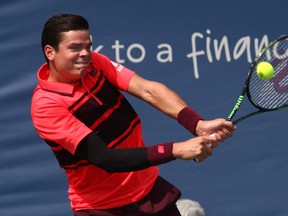 Milos Raonic of Thornhill, Ont., returns the ball to Feliciano Lopez at the Western & Southern Open Tuesday, Aug. 18, 2015, in Mason, Ohio. (AP Photo/Tom Uhlman)