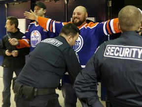 Security searches hockey fans prior to the start of the Edmonton Oilers and Washington Capitals NHL action at Rexall Place, in Edmonton Alta., on Wednesday Oct. 22, 2014. David Bloom/Edmonton Sun