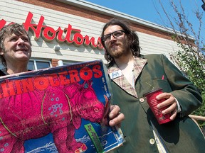 Rhinoceros Party leader Sebastien CoRhino Corriveau, right, and candidate Ben 97 Benoit stand in front of a coffee shop Monday, Aug. 17, 2015 in Montreal. THE CANADIAN PRESS/Paul Chiasson