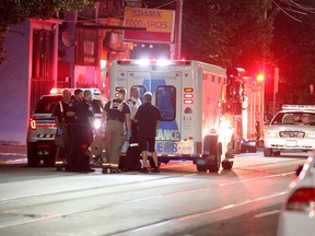 Officials at the scene on Dundas east of Sherbourne where a man was found dead early Wednesday, Aug. 19, 2015. (JOHH HANLEY/Special to the Toronto Sun)