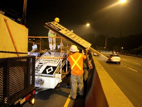 Crews from Almon Equipment Ltd. and City of Toronto remove HOV signs and markings early Wednesday morning. (NICK WESTOLL, Toronto Sun)