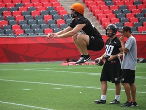With kicker Chris Milo watching on, new Ottawa RedBlacks punter Andy Wilder stretches out as he prepares to punt during practice Wednesday at TD Place. (TIM BAINES/OTTAWA SUN)