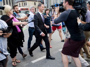 Members of the media attempt to ask questions to Nigel Wright, former Chief of Staff to Prime Minister Stephen Harper, as he leaves the courthouse in Ottawa following his sixth day of testimony at the trial of former Conservative Senator Mike Duffy on Aug. 19, 2015. THE CANADIAN PRESS/Justin Tang