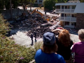 Residents watch as South Kitsap County Fire Department members remove debris after a gas explosion at the Motel 6 in Bremerton, Washington August 19, 2015. (REUTERS/Matt Mills McKnight)