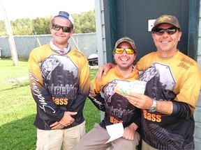 The local father-son team of David (left) and Gabe Feher (right) collect their first-place prize from Nickel City Bass club president Marty Guenette on the weekend. The duo finished first and second in a pair of events last weekend.