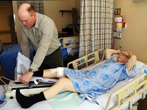LUKE HENDRY/THE INTELLIGENCER
Physiotherapist Ed Dowling adjusts an exercise machine beneath Jack Evans' leg.