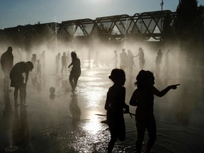 In this July 12, 2015 file photo, people cool down in a fountain beside the Manzanares river in Madrid, Spain. Spain's national weather agency says July was the country's hottest month on record. (AP Photo/Oscar del Pozo, File)