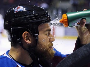 Colorado Avalanche centre Ryan O'Reilly cools off with a splash of water to the face before the start of a pre-season game against the Los Angeles Kings in Colorado Springs, Colo., on Oct. 2, 2014. (THE CANADIAN PRESS/AP, Jack Dempsey)