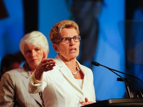 Ontario Premier Kathleen Wynne speaks at the 2014 annual meeting of the Elementary Teachers Federation of Ontario in Toronto on Aug. 13, 2014.  Education Minister Liz Sandals stands behind Wynne.  (Stan Behal/Toronto Sun files)