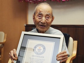 Yasutaro Koide, 112, holds the Guinness World Records certificate as he is formally recognized as the world's oldest man at a nursing home in Nagoya, central Japan, on Aug. 21, 2015. (AP Photo/Koji Sasahara)