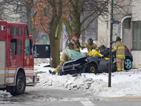 Firefighters look at the damage to a Volkswagen car after it was pulled off of a tree following an early morning single-vehicle crash on Perth Drive near University Hospital in London, Ontario at approximately 3:20 a.m. on Sunday, Jan. 18, 2015.  One occupant of the vehicle was pronounced dead at the scene, while two others were taken to hospital. (Free Press file photo)