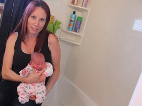 Sarnia mother April Rathmell shows off the bathtub where she delivered her daughter Kayleigh Margaret by herself early Thursday morning. The 34-year-old mother of two hadn't realized the cramps she had been experiencing was labour rather than pains from exercising until it was too late. (Barbara Simpson, The Observer)