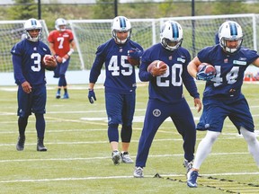 Argos running backs (from left) Brandon Whitaker, Brendan Gillanders, Henry Josey and Chad Kackert take part in some drills during yesterday’s practice. (MICHAEL PEAKE, Toronto Sun)