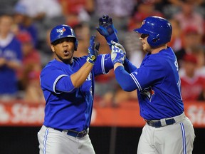 Toronto Blue Jays first baseman Justin Smoak, right, is congratulated by teammate Edwin Encarnacion after hitting a two-run home run during the seventh inning against the Los Angeles Angels Friday, Aug. 21, 2015, in Anaheim, Calif. (AP Photo/Mark J. Terrill)