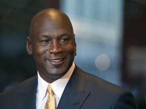 Michael Jordan smiles at reporters after a jury ordered a defunct grocery store chain to pay him $8.9 million for using his name without permission. Friday, Aug. 21, 2015, in Chicago. Jurors had to calculate how much the now-defunct grocery chain Dominick's Finer Foods should pay Jordan for invoking his name in an ad without permission. They sent one note to the judge, saying: "We need a calculator." (AP Photo/Charles Rex Arbogast)
