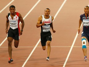Turkey's Jak Ali Harvey (left), Canada's Andre De Grasse (centre) and France's Jimmy Vicaut (right) compete in a men's 100m second round heat at the World Athletics Championships in Beijing on Saturday, Aug. 22, 2015. (Mark Schiefelbein/AP Photo)