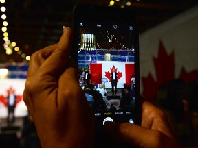 An onlooker snaps a photo of Conservative  leader Stephen Harper during a rally in Black Creek, British Columbia on Thursday, August 20, 2015.  THE CANADIAN PRESS/Sean Kilpatrick