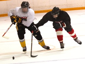 Legionnaires hopefuls Cameron Rannie, left, and Ryan Emerson, battle for a puck Saturday during a scrimmage at the 'Jr. B' hockey team's evaluation camp. About 60 players were taking part in the two-day camp at Sarnia's Clearwater Arena, hoping to earn one of 23 roster spots. Tyler Kula/Sarnia Observer/Postmedia Network