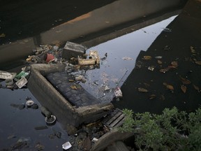 A discarded sofa lies in polluted water in a canal at the Mare slum complex in Rio de Janeiro, Brazil, on July 31, 2015. In Rio, much of the waste runs through open-air ditches to fetid streams and rivers that feed the Olympic water sites and blight the city's picture postcard beaches. (Leo Correa/AP Photo)