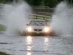 A car ploughs through a water over a road near Route 90 and Portage Avenue, Saturday, August 22, 2015. Heavy rain flooded some streets in Winnipeg.  This was the scene close to Route 90 and Portage Avenue.