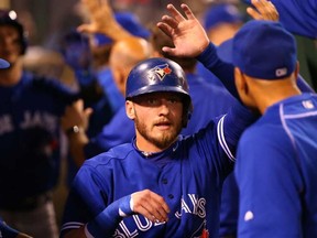 Josh Donaldson #20 of the Toronto Blue Jays celebrates with teammates in the dugout after scoring on a triple by teammate Jose Bautista #19 in the fourth inning during the MLB game against the Los Angeles Angels of Anaheim at Angel Stadium of Anaheim on August 22, 2015 in Anaheim, California.  Victor Decolongon/Getty Images/AFP