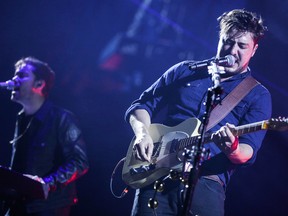 Marcus Mumford, right, and Ben Lovett of Mumford & Sons perform at The Forum on Monday, Aug. 17, 2015, in Inglewood, Calif. (Photo by Rich Fury/Invision/AP)
