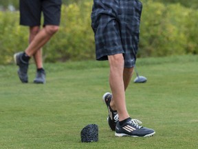 Allen McGee watches as his son Hunter tees off during play in the Flagstick Open division of the Ottawa Sun Scramble at the Talon @ Greyhawk on Friday August 22, 2014. Errol McGihon/Ottawa Sun/QMI Agency