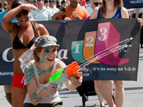 The Ottawa Capital Pride Parade had 10s of thousands enjoying hundreds of participants from all walks of life in downtown Ottawa on Sunday August 23, 2015. Flynn Strathbarn shooting water at thew crowd. Errol McGihon/Ottawa Sun/Postmedia Network
