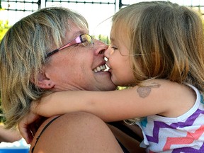 Cancer survivor Kathy Poirier, of London, gets a big kiss from grand-daughter Gabby Poirier, 3, during a charity walk to raise money for head and neck cancer research, at TD Waterhouse stadium on Sunday. (MORRIS LAMONT, The London Free Press)