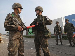 South Korean army soldiers stand guard on Unification Bridge, which leads to the demilitarized zone, near the border village of Panmunjom in Paju, South Korea, Monday, Aug. 24, 2015. Marathon negotiations by senior officials from the Koreas stretched into a third day on Monday as the rivals tried to pull back from the brink. South Korea's military, meanwhile, said that unusual North Korean troop and submarine movement indicated continued battle preparation. (AP Photo/Ahn Young-joon)