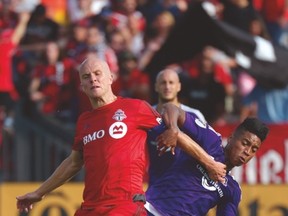 TFC’s Michael Bradley fights for the ball with Orlando’s Cristian Higuita during Saturday’s game. (CP)