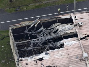 A warehouse which caught fire after an explosion is seen at the U.S. Army Sagami General Depot in Sagamihara, southwest of Tokyo, Japan, in this aerial photo taken by Kyodo August 24, 2015. An explosion rocked a warehouse at a U.S. military base in Sagamihara, Japan, but there were no reports of injuries, Japanese fire officials said on Monday. Mandatory credit REUTERS/Kyodo