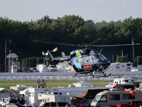 A helicopter lifts off at Pocono Raceway carrying race car driver Justin Wilson, of England, after he was involved in a crash during the Pocono IndyCar 500 auto race Sunday, Aug. 23, 2015, in Long Pond, Pa. (AP Photo/Mel Evans)