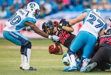 Ottawa RedBlacks' Brad Sinopoli, centre, is tackled by Toronto Argonauts' Travis Hawkins, left, and Cory Greenwood during the second half of CFL football action in Toronto on Sunday, August 23, 2015. THE CANADIAN PRESS/Mark Blinch