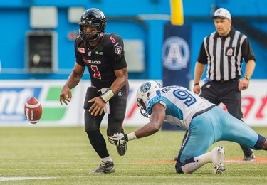 Ottawa RedBlacks' quarterback Henry Burris, left, fumbles the ball as Toronto Argonauts' Tristan Okpalaugo dives during the second half of CFL football action in Toronto on Sunday, August 23, 2015. THE CANADIAN PRESS/Mark Blinch