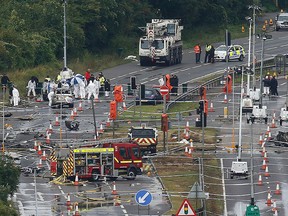 A crane arrives on site as emergency services and crash investigation officers continue to work at the site where a Hawker Hunter fighter jet crashed onto the A27 road at Shoreham near Brighton, Britain Aug. 24, 2015.  REUTERS/Luke MacGregor