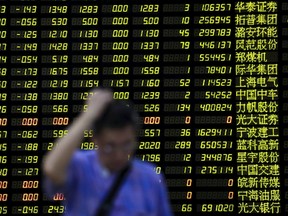 An investor stands in front of an electronic board showing stock information at a brokerage house in Shanghai, China, August 24, 2015. (REUTERS/Aly Song)