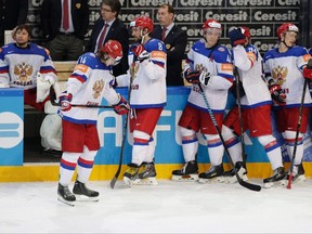 Dejected Russia's players watch as Canada's players celebrate their 6-1 at the Hockey World Championships gold medal match in Prague, Czech Republic on May 17, 2015. The Russian Hockey Federation was fined Monday over the national team snubbing Canada's victory celebrations after the world championship final. The sport's governing body, IIHF, said the Russian players deliberately left the ice before Canada's national anthem was played after a signal from captain Ilya Kovalchuk. (THE CANADIAN PRESS/AP, Sergei Grits)