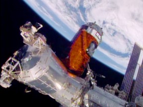 In a photo provided by NASA, a cargo ship from a Japanese company is bolted into place on the International Space Station on Aug. 24, 2015. A Japanese company known for its whisky and other alcoholic beverages included five types of distilled spirits in the cargo ship that arrived at the space station Monday. The samples will spend at least a year in orbit to see if alcoholic beverages mellow the same in space as they do on Earth. (NASA via AP)