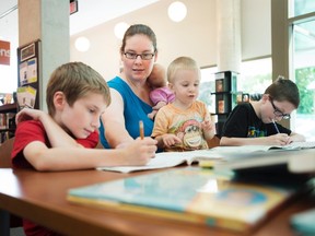 Lisa Marie Fletcher, second from left, helps her children with math lessons at the Whitby Central Library in Whitby, Ont. on Tuesday, August 11, 2015. The children are, from left to right, Tristan, 7, Ellissa, 2 months, Sebastian, 2, and William, 11. (The Canadian Press/Darren Calabrese)